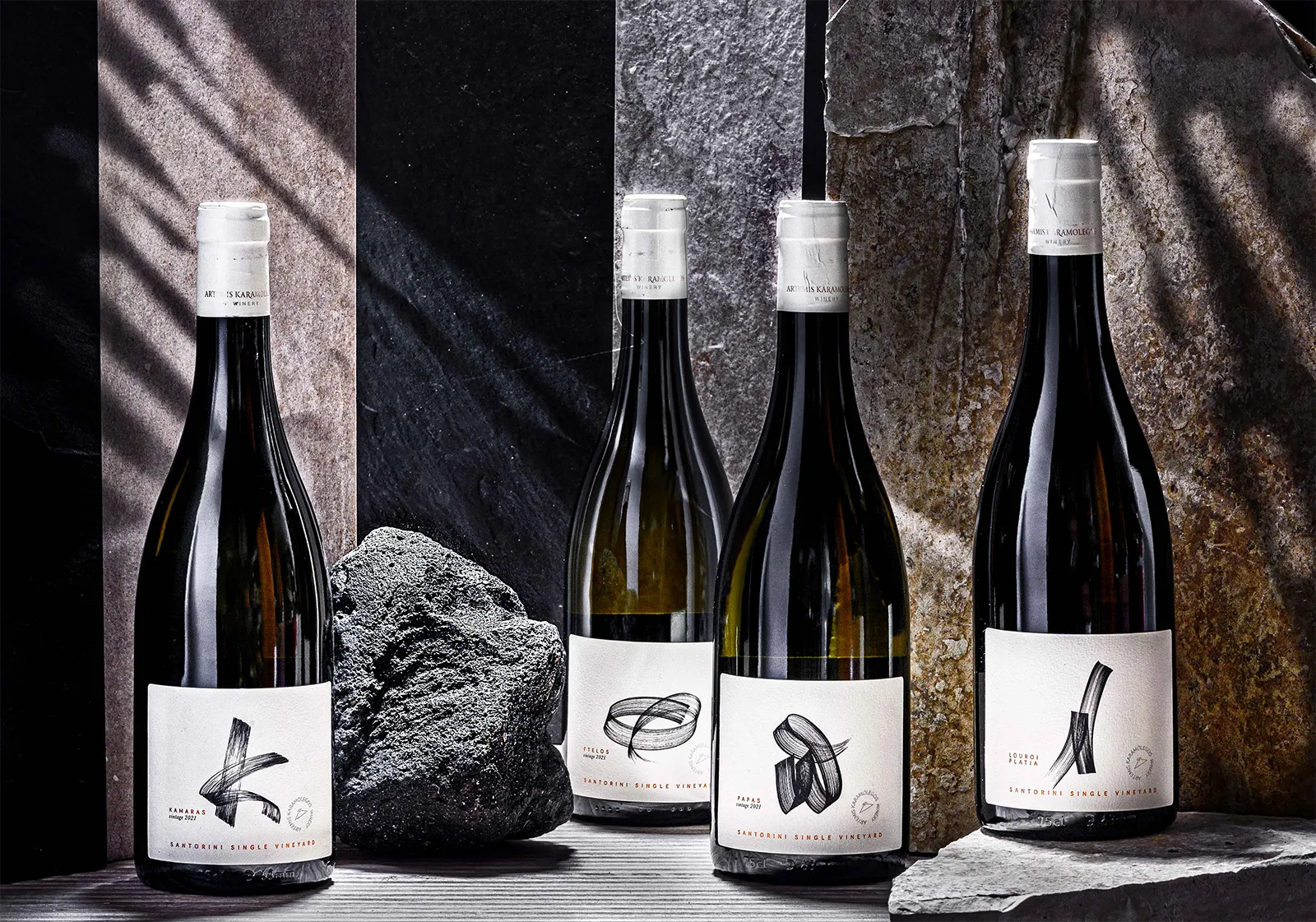 The Sinle Vineyard collection in a grey background and a stone of the volcanic soil.