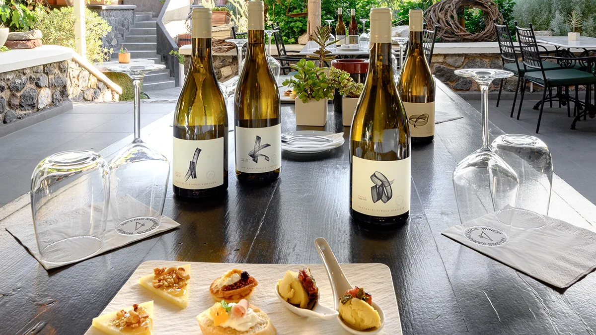 Four different labels of the Single Vineyard collection combining with food in a black table.